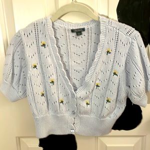 Blue knitted kind of look sweater with flowers on it